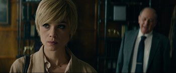 Movie still from “The Vault” (2021), directed by Jaume Balagueró – A person with short blonde hair; Close Up shot, Over the shoulder angle