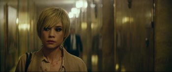 Movie still from “The Vault” (2021), directed by Jaume Balagueró – A woman with short blonde hair standing in front of a building; Close Up shot, High angle