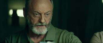 Movie still from “The Vault” (2021), directed by Jaume Balagueró – An old man with a beard and a green shirt; Close Up shot, Low angle