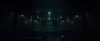 Movie still from “The Vault” (2021), directed by Jaume Balagueró – A dark room with lights on the ceiling and walls; Extreme Wide shot, Low angle