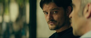 Movie still from “The Vault” (2021), directed by Jaume Balagueró – A person wearing a black shirt; Close Up shot, Over the shoulder angle