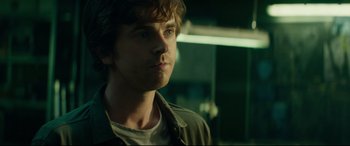 Movie still from “The Vault” (2021), directed by Jaume Balagueró – A young man is looking into the distance; Close Up shot, Over the shoulder angle