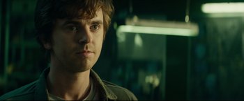 Movie still from “The Vault” (2021), directed by Jaume Balagueró – A person wearing a jacket and staring straight ahead; Close Up shot, Over the shoulder angle