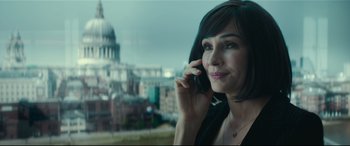 Movie still from “The Vault” (2021), directed by Jaume Balagueró – A woman talking on a cell phone in front of a building; Close Up shot, Over the shoulder angle