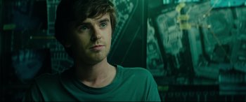 Movie still from “The Vault” (2021), directed by Jaume Balagueró – A person wearing a green shirt; Close Up shot, Over the shoulder angle
