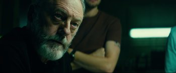 Movie still from “The Vault” (2021), directed by Jaume Balagueró – An old man with a beard and a man with a tattoo; Close Up shot, Over the shoulder angle