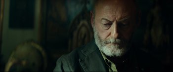 Movie still from “The Vault” (2021), directed by Jaume Balagueró – An older man with a beard and a jacket; Close Up shot, Low angle