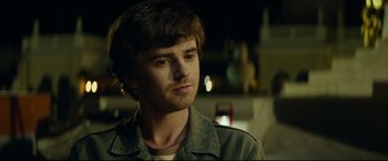 Movie still from “The Vault” (2021), directed by Jaume Balagueró – A young man with a beard is looking to his left; Close Up shot, Over the shoulder angle