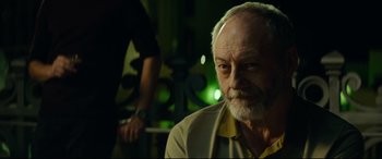 Movie still from “The Vault” (2021), directed by Jaume Balagueró – An older man is sitting in a dark room; Close Up shot, Over the shoulder angle