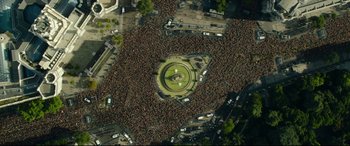 Movie still from “The Vault” (2021), directed by Jaume Balagueró – An aerial view of a crowd of people gathered in a park; Extreme Wide shot, Overhead angle