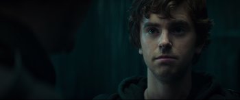 Movie still from “The Vault” (2021), directed by Jaume Balagueró – A person's face in a dark room; Close Up shot, Over the shoulder angle