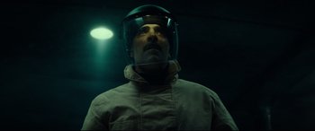 Movie still from “The Vault” (2021), directed by Jaume Balagueró – A man wearing a helmet is looking into the distance; Close Up shot, Low angle