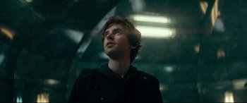 Movie still from “The Vault” (2021), directed by Jaume Balagueró – A man standing in a dark room looking up; Close Up shot, Low angle