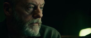 Movie still from “The Vault” (2021), directed by Jaume Balagueró – An old man with a beard and a goatee looking to his left; Close Up shot, Low angle