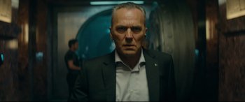 Movie still from “The Vault” (2021), directed by Jaume Balagueró – A person wearing a suit and ear buds; Close Up shot, Low angle