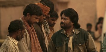 Movie still from “The White Tiger” (2021), directed by Ramin Bahrani – A group of men standing next to each other; Medium shot, Over the shoulder angle