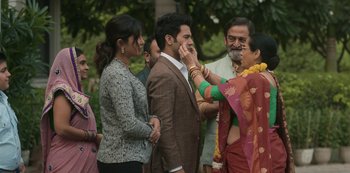 Movie still from “The White Tiger” (2021), directed by Ramin Bahrani – A group of people standing next to each other; Medium shot, Over the shoulder angle