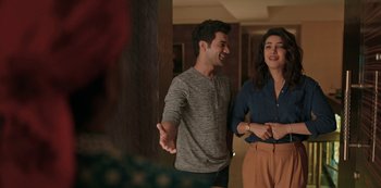 Movie still from “The White Tiger” (2021), directed by Ramin Bahrani – A man and a woman standing next to each other in a room; Medium shot, Over the shoulder angle