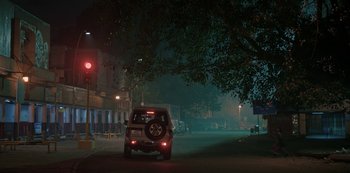 Movie still from “The White Tiger” (2021), directed by Ramin Bahrani – A car driving down a street at night; Extreme Wide shot, High angle