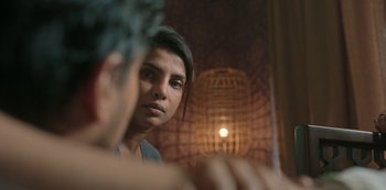 Movie still from “The White Tiger” (2021), directed by Ramin Bahrani – A woman looking at a man in a mirror; Close Up shot, Over the shoulder angle