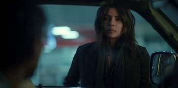 Movie still from “The White Tiger” (2021), directed by Ramin Bahrani – A woman is standing in a car looking at the camera; Close Up shot, Over the shoulder angle
