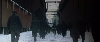 Movie still from “Road to Perdition” (2002), directed by Sam Mendes – A group of people walking down a snow covered street; Extreme Wide shot, High angle