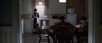 Movie still from “Road to Perdition” (2002), directed by Sam Mendes – A man and a woman are in a kitchen; Wide shot, High angle