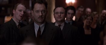Movie still from “Road to Perdition” (2002), directed by Sam Mendes – A group of men in suits standing next to each other; Medium shot, Low angle