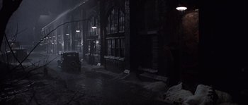 Movie still from “Road to Perdition” (2002), directed by Sam Mendes – A car parked on the side of the road in the dark; Extreme Wide shot, High angle