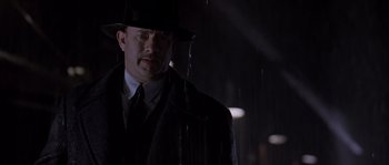 Movie still from “Road to Perdition” (2002), directed by Sam Mendes – A man wearing a hat and a suit standing in the rain; Close Up shot, Low angle