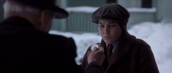 Movie still from “Road to Perdition” (2002), directed by Sam Mendes – A young man holding a baseball while wearing a hat; Close Up shot, Over the shoulder angle