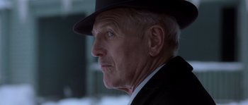 Movie still from “Road to Perdition” (2002), directed by Sam Mendes – An older man wearing a black hat and a black suit; Close Up shot, Low angle