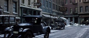 Movie still from “Road to Perdition” (2002), directed by Sam Mendes – Old cars parked on the side of the street in the snow; Wide shot, High angle