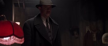 Movie still from “Road to Perdition” (2002), directed by Sam Mendes – A man wearing a hat and a coat; Medium shot, Low angle