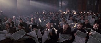 Movie still from “Road to Perdition” (2002), directed by Sam Mendes – A large group of people are reading newspapers; Wide shot, High angle