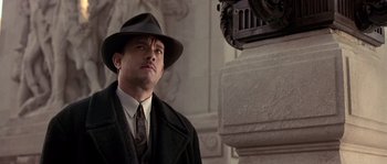 Movie still from “Road to Perdition” (2002), directed by Sam Mendes – A man wearing a hat and a suit; Medium shot, Low angle