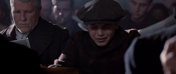 Movie still from “Road to Perdition” (2002), directed by Sam Mendes – A young boy wearing a hat and a coat; Close Up shot, Low angle