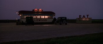 Movie still from “Road to Perdition” (2002), directed by Sam Mendes – An old car parked in front of a diner at night; Extreme Wide shot, High angle