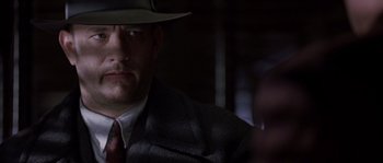 Movie still from “Road to Perdition” (2002), directed by Sam Mendes – A man wearing a hat and a suit and tie; Close Up shot, Low angle