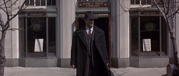 Movie still from “Road to Perdition” (2002), directed by Sam Mendes – A man in a black coat and a black hat; Wide shot, Low angle