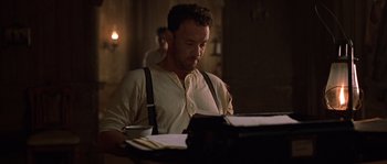 Movie still from “Road to Perdition” (2002), directed by Sam Mendes – A man sitting in front of an old fashioned typewriter; Medium shot, Low angle
