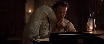 Movie still from “Road to Perdition” (2002), directed by Sam Mendes – A man sitting in front of a computer; Medium shot, Low angle