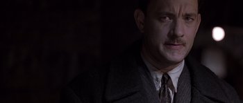 Movie still from “Road to Perdition” (2002), directed by Sam Mendes – A person wearing a suit and tie; Close Up shot, Over the shoulder angle