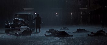 Movie still from “Road to Perdition” (2002), directed by Sam Mendes – A group of dead bodies laying on the ground in the dark; Wide shot, High angle