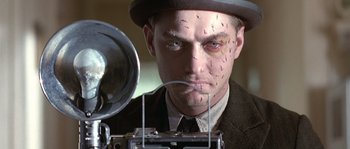 Movie still from “Road to Perdition” (2002), directed by Sam Mendes – A person wearing a suit and a hat; Close Up shot, Low angle