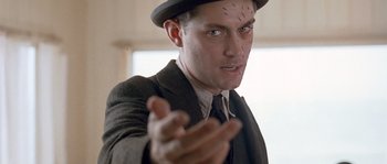 Movie still from “Road to Perdition” (2002), directed by Sam Mendes – A man wearing a suit and a hat; Close Up shot, Low angle