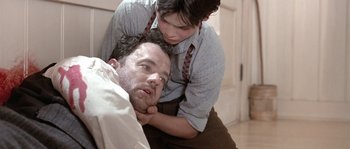 Movie still from “Road to Perdition” (2002), directed by Sam Mendes – A man and a woman laying on the floor; Close Up shot, Low angle