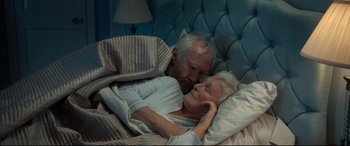 Movie still from “The Wife” (2017), directed by Björn Runge – An older man and woman laying in a bed together; Medium shot, Overhead angle