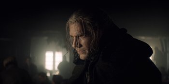 Movie still from “The Witcher” (2019), created by Lauren Schmidt Hissrich – A man with long white hair is looking down; Close Up shot, Low angle