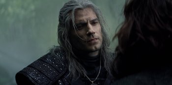 Movie still from “The Witcher” (2019), created by Lauren Schmidt Hissrich – A man with long grey hair is looking at the camera; Close Up shot, Over the shoulder angle